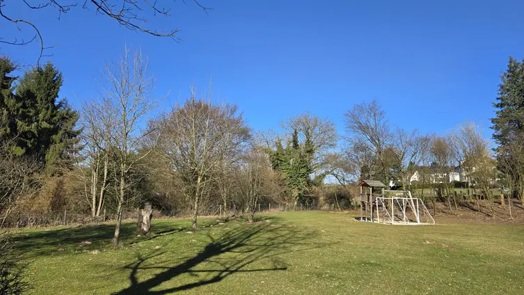 Garten mit Bäumen und Toren im Hintergrund
