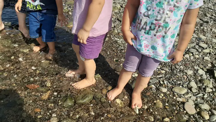 Das Foto zeigt Kinderfüße im Wasser.