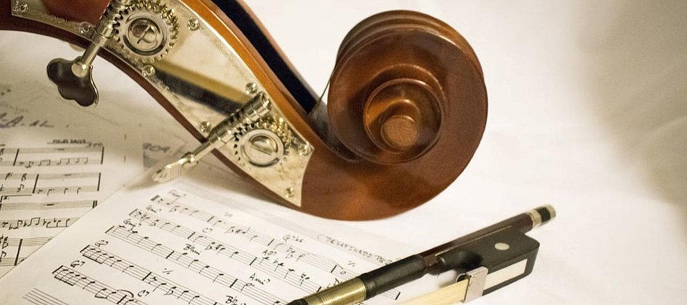 Ansicht der Schnecke einer Geige und Bogen auf Notenblättern