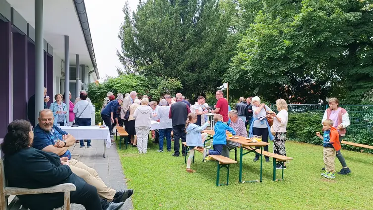 Menschen verschiedenen Alters auf der Wiese der ev. Kirche Herrnsheim