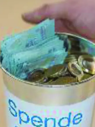Eine offene Spendendose mit Münzen und Scheinen. Die Dose trägt den Schriftzug 