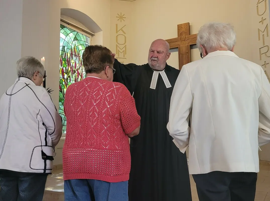 Pfarrer Nikolaus Krause segnet Frauen im Gottesdienst.