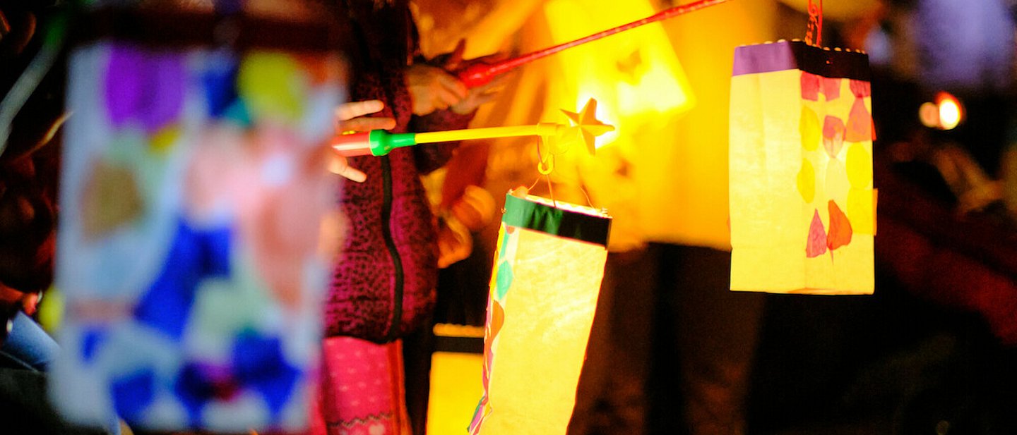 Kinder mit bunten, selbst gebastelten Laternen