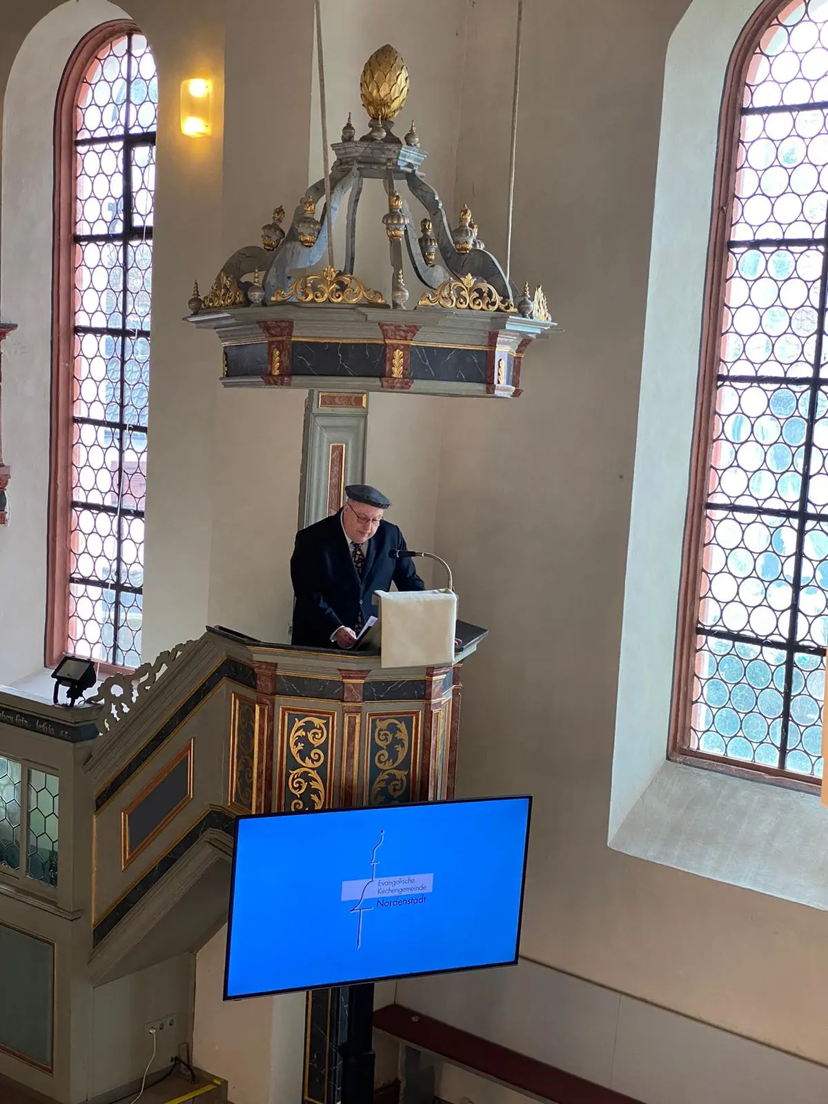 Prädikant Martin Maurer mit Mütze beim Witze erzählen.