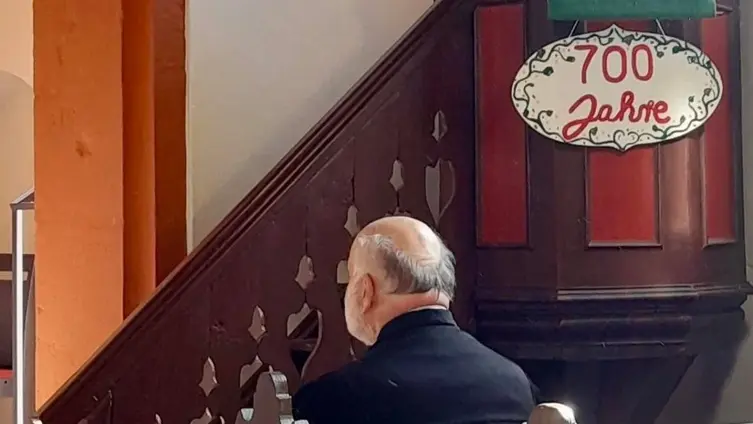 Pfarrer Winfried Klotz vor der Kanzel mit dem Schild 700 Jahre