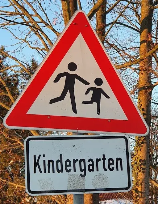 Straßenschild Kindergarten Ein Straßenschild weist darauf hin, dass ein Kindergarten in der Nähe ist, damit Autofahrer aufmerksamer sind
