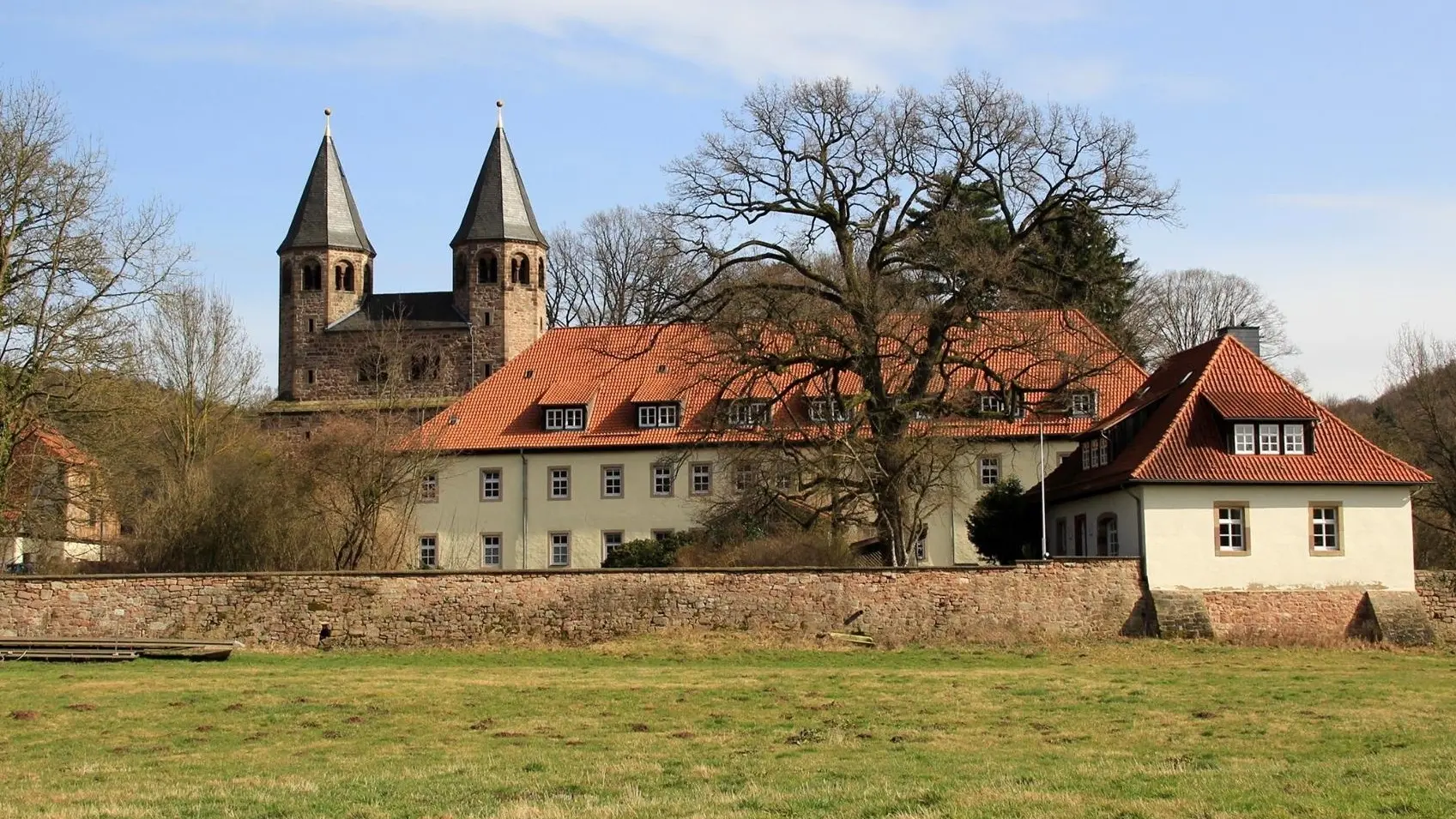 Die Klosterkirche liegt links, etwas hinter dem Tagungsgebäude. Ein alte Mauer umschließt alles.