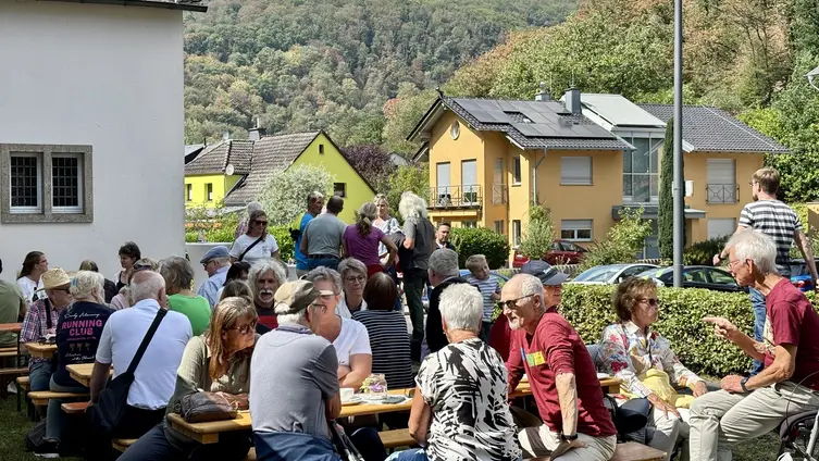 Gäste eines Festes sitzen auf Biertischgarnituren