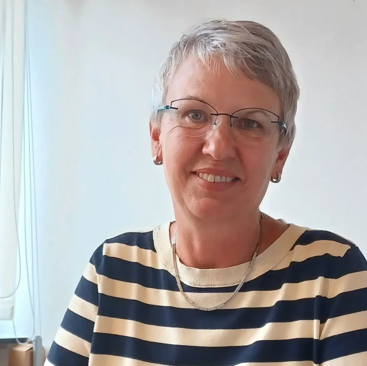 Portrait von Kerstin Heinrich an einem Schreibtisch sitzend 