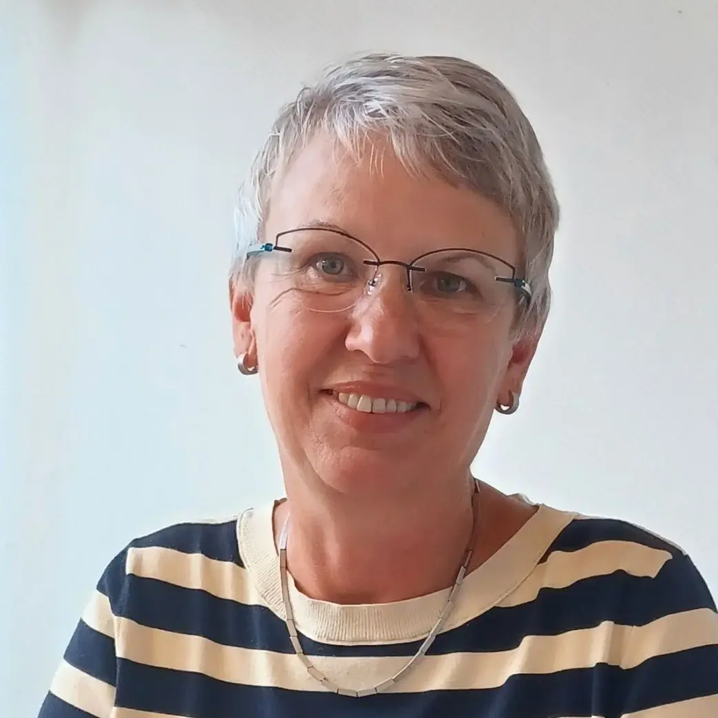 Portrait von Kerstin Heinrich an einem Schreibtisch sitzend 