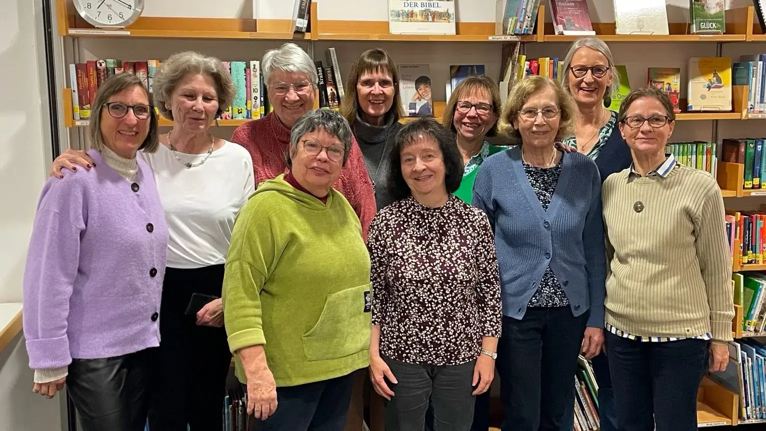 Das zehnköpfige Team der Gemeindebücherei Köppern vor einer Bücherwand. Von links nach rechts in der hinteren Reohe: Eva Schneider, Helga Jannek, Luise Feld, Susanne Grünert, Alexandra Bugiel, Gitta Groth. Vorn: Susanne Schniedewind, Carmen Schmitt-Bittner,  Gabriele Wofgram und Marie-Pierre Hermes.