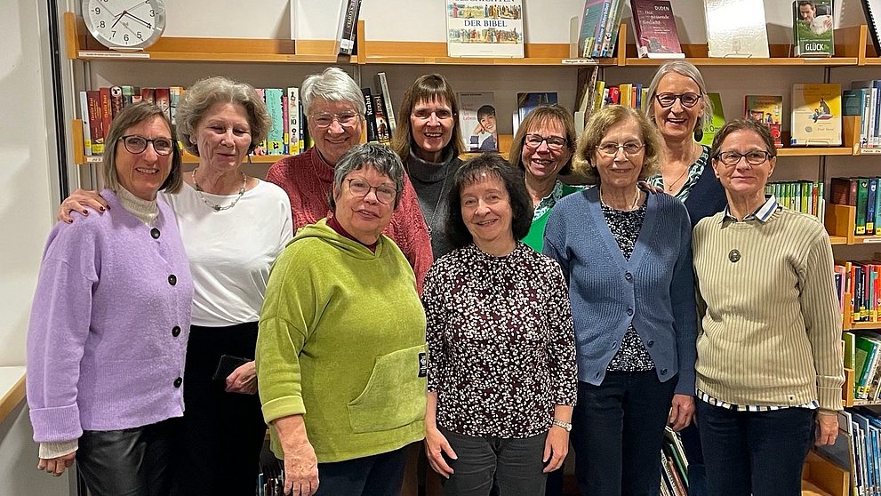 Das zehnköpfige Team der Gemeindebücherei Köppern vor einer Bücherwand. Von links nach rechts in der hinteren Reohe: Eva Schneider, Helga Jannek, Luise Feld, Susanne Grünert, Alexandra Bugiel, Gitta Groth. Vorn: Susanne Schniedewind, Carmen Schmitt-Bittner,  Gabriele Wofgram und Marie-Pierre Hermes.