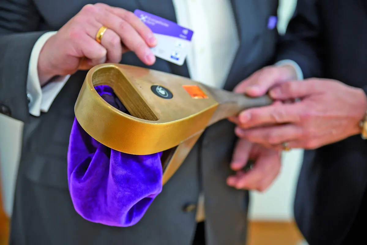 Digitaler Klingelbeutel_001 Zwei Personen im Bild - eine Person hält einen Klingelbeutel in seinen Händen. Die andere Person versucht mit einer Girocard zu bezahlen. Es sind keine Gesichter im Bild. Farbaufnahme.