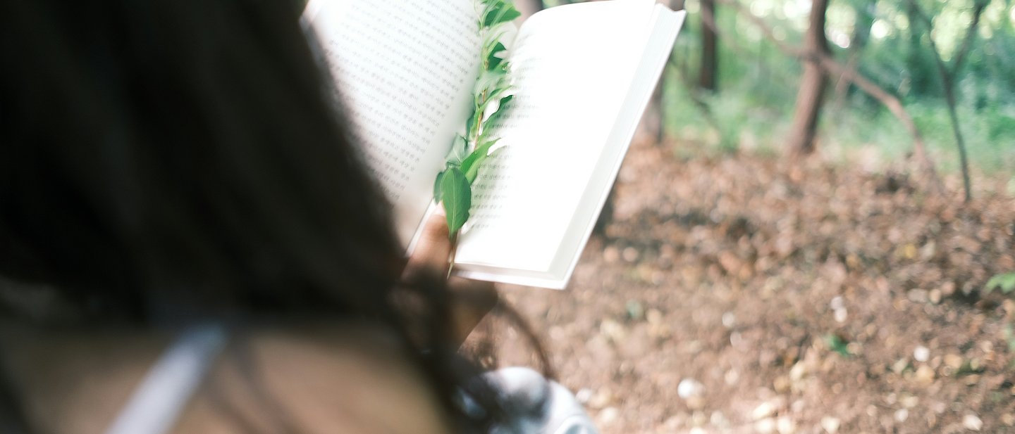Frau liest in der Natur