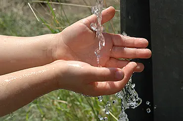 Kinderhänder unter einem Wasserstrahl