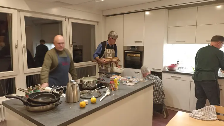 Kochmützentreffen 30.01.2026. mehrere Personen stehen am Küchenblock und kochen