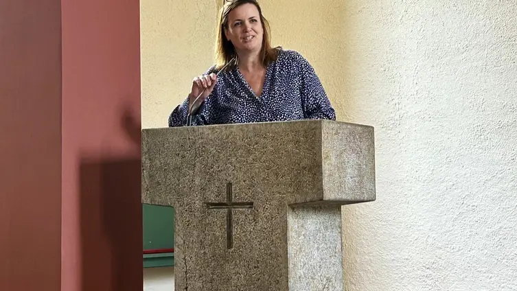 Gastrednerin Katharina Voss spricht von der Kanzel und hält das Mikro fest