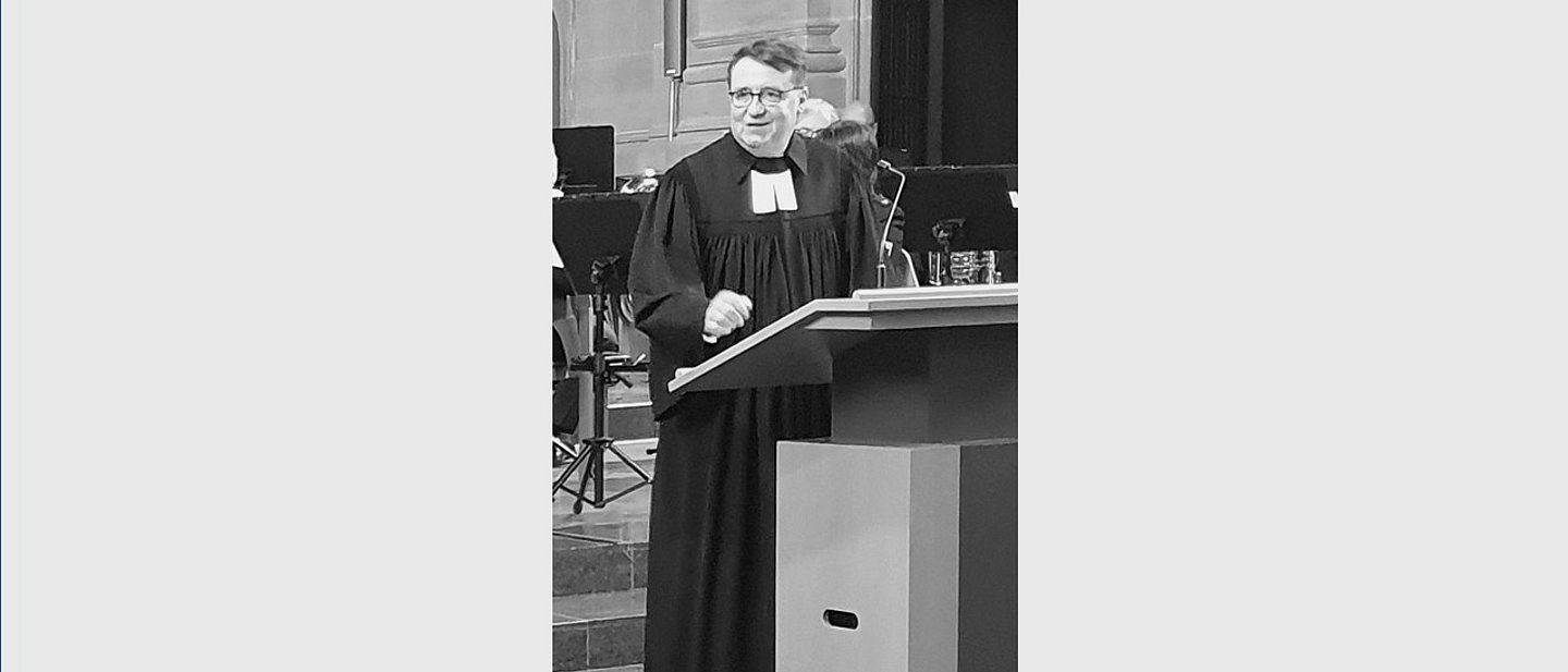 Das schwarz-weiß Foto zeigt Christof Schuster bei einer Predigt