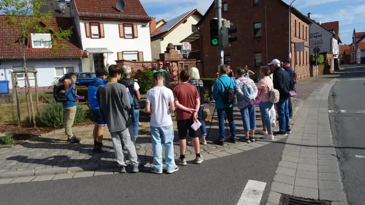 Das Foto zeigt ca. 15 Gottesdienstteilnehmende am Ehrenmal in Hainstadt.