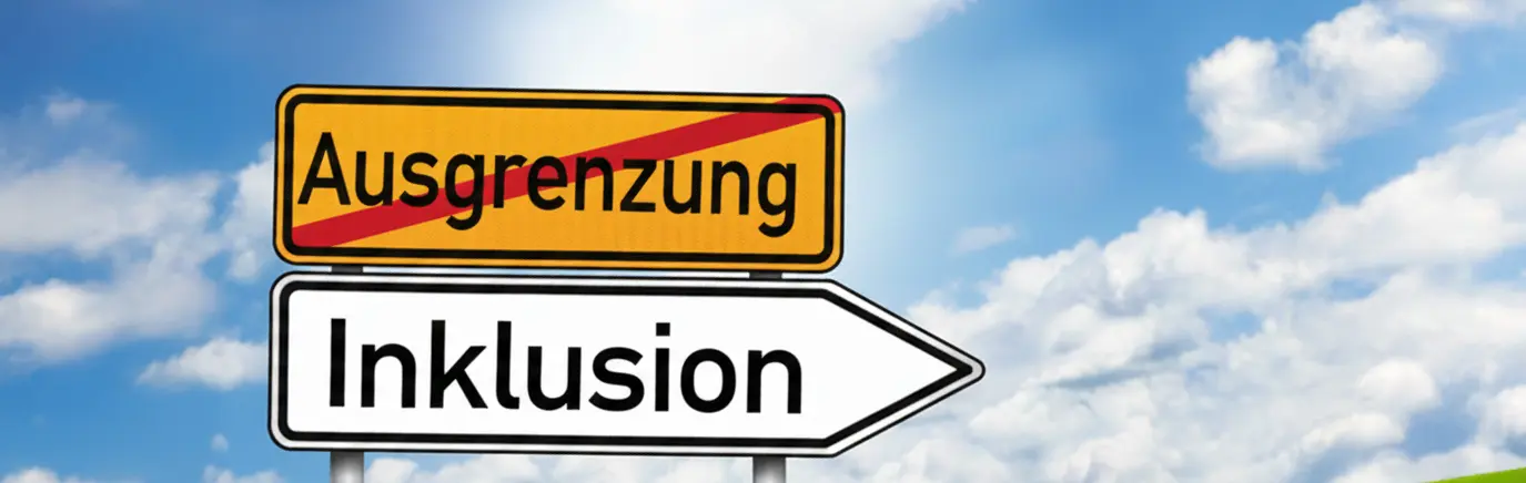 Vor blauem Himmel stehen zwei Straßenschilder: Das obere, gelbe Schild mit dem Wort „Ausgrenzung“ ist rot durchgestrichen. Darunter zeigt ein weißes Pfeilschild nach rechts und trägt die Aufschrift „Inklusion“.