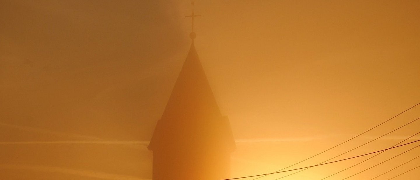 Kirchturm im morgendlichen Nebel