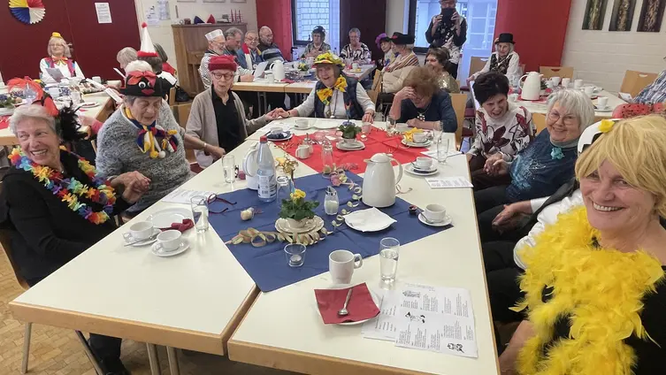 Fastnachtlich gekleidete Senioren schunkeln beim närrischen Seniorennachmittag im katholischen Pfarrheim Ginsheim