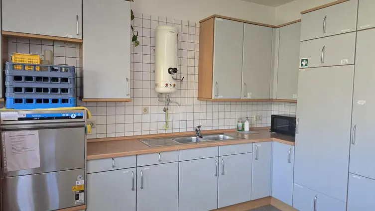 Küche mit Schränken, Spülmaschine und Wasserboiler