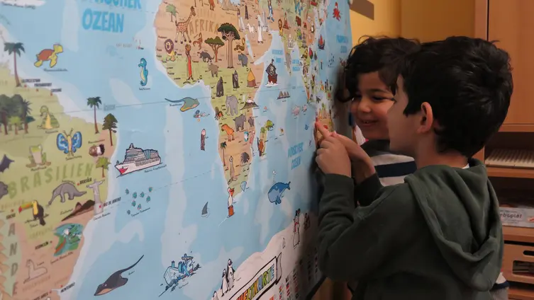 2 Kinder vor einer Landkarte