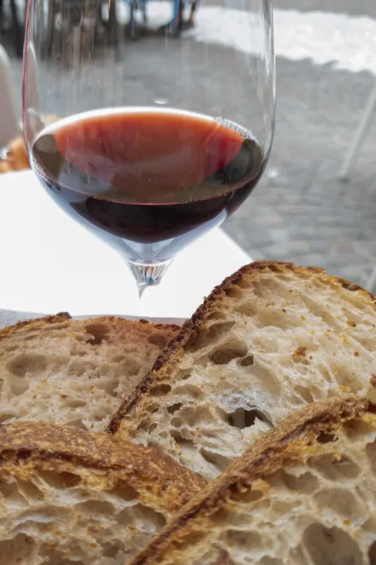 Vier Scheiben Brot und und ein Glas Wein, gefüllt mit Rotwein