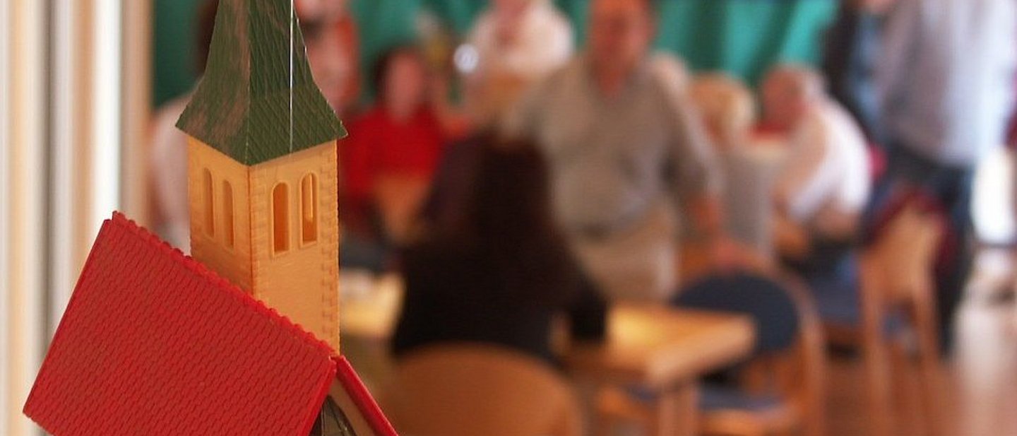 Modell einer Kirche mit Menschen im Hintergrund