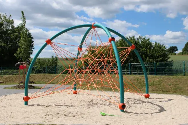 Ein modernes Klettergerüst steht auf einer Wiese.