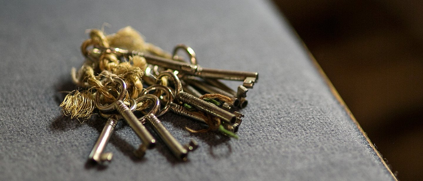 Schlüsselbund liegt auf grauem Stoff, vrmtl. Sitzpolster der Kirchenbank