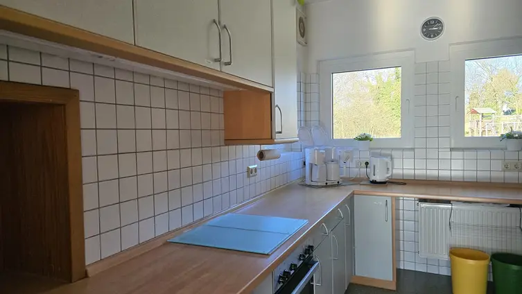 Küche mit Arbeitszeile, Herd und Kaffeemaschinen