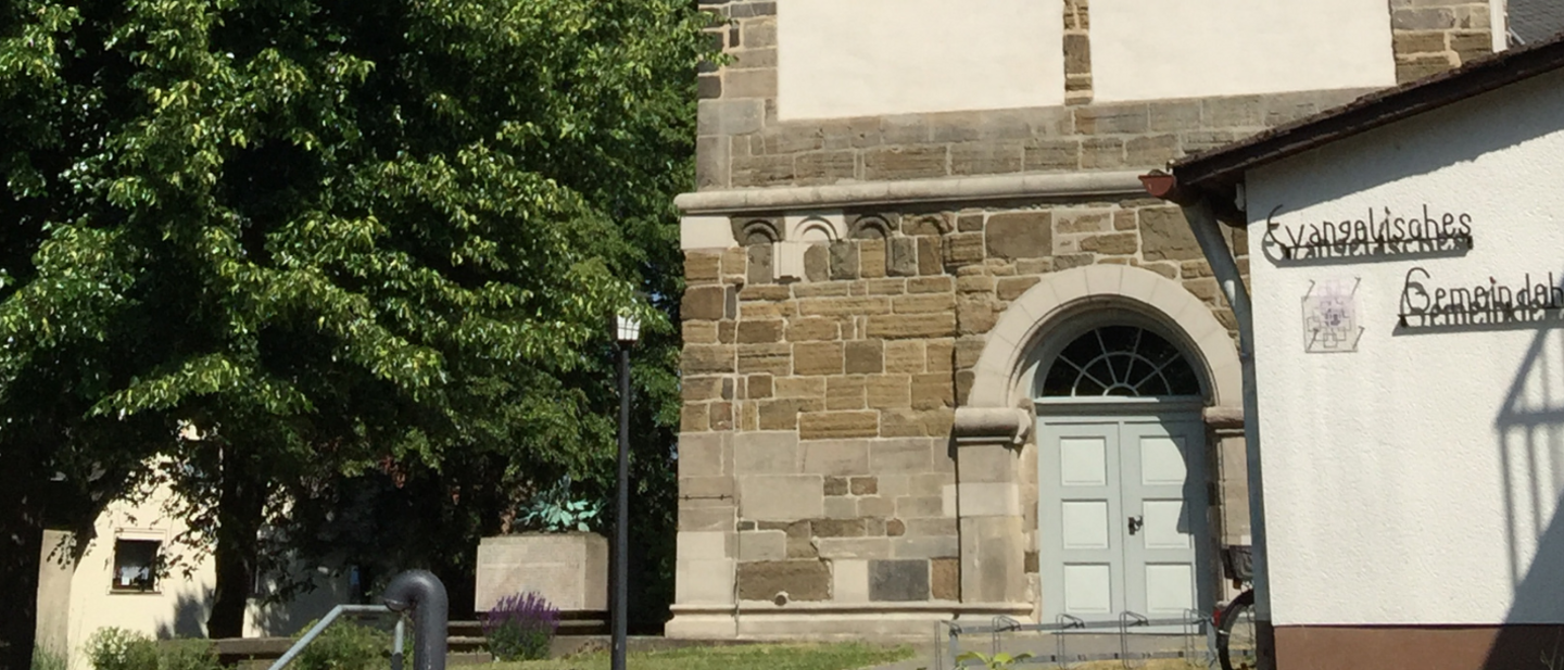 Eingangstür einer Kirche und Wand von einem Gemeindehaus