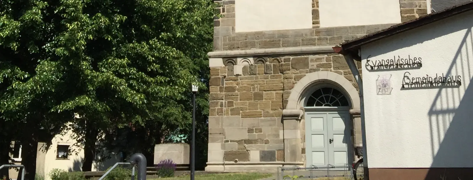 Eingangstür einer Kirche und Wand von einem Gemeindehaus