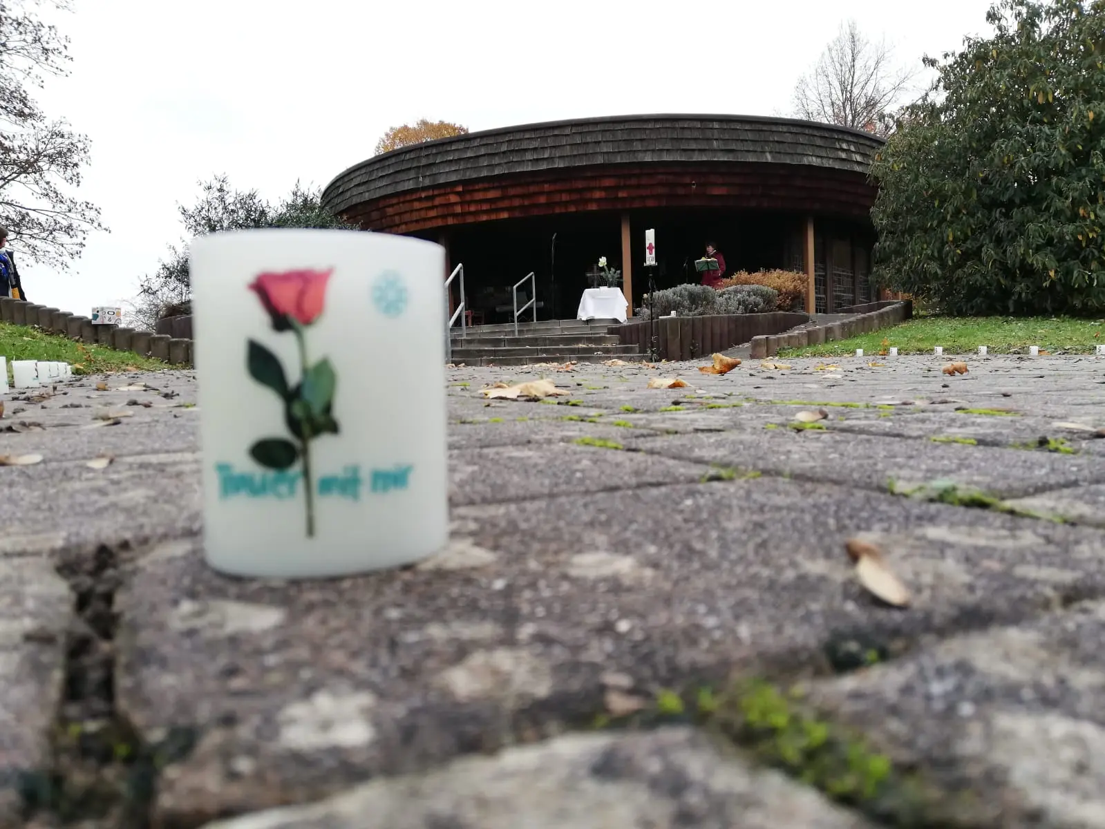 Im Vordergrund eine Kerze, dahinter die Trauerhalle