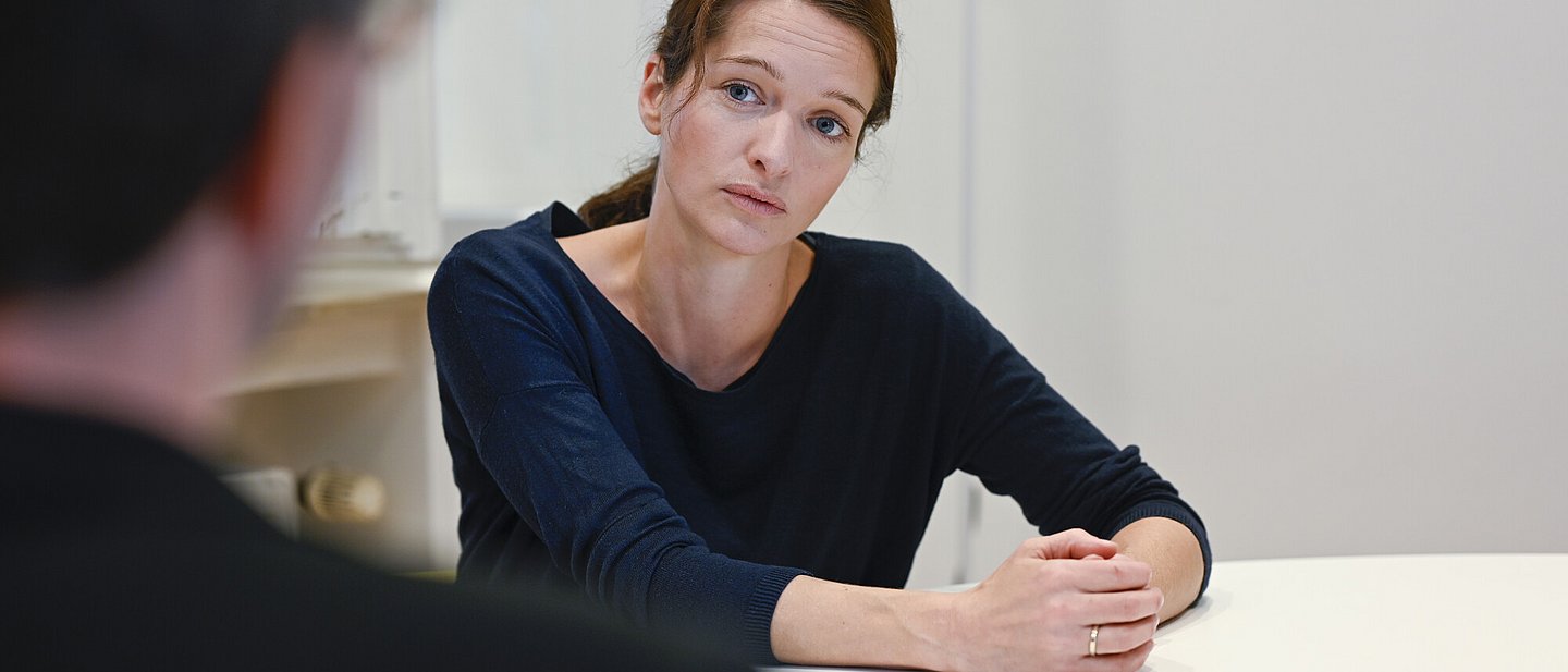 Frau schaut besorgt, spricht mit einem Mann