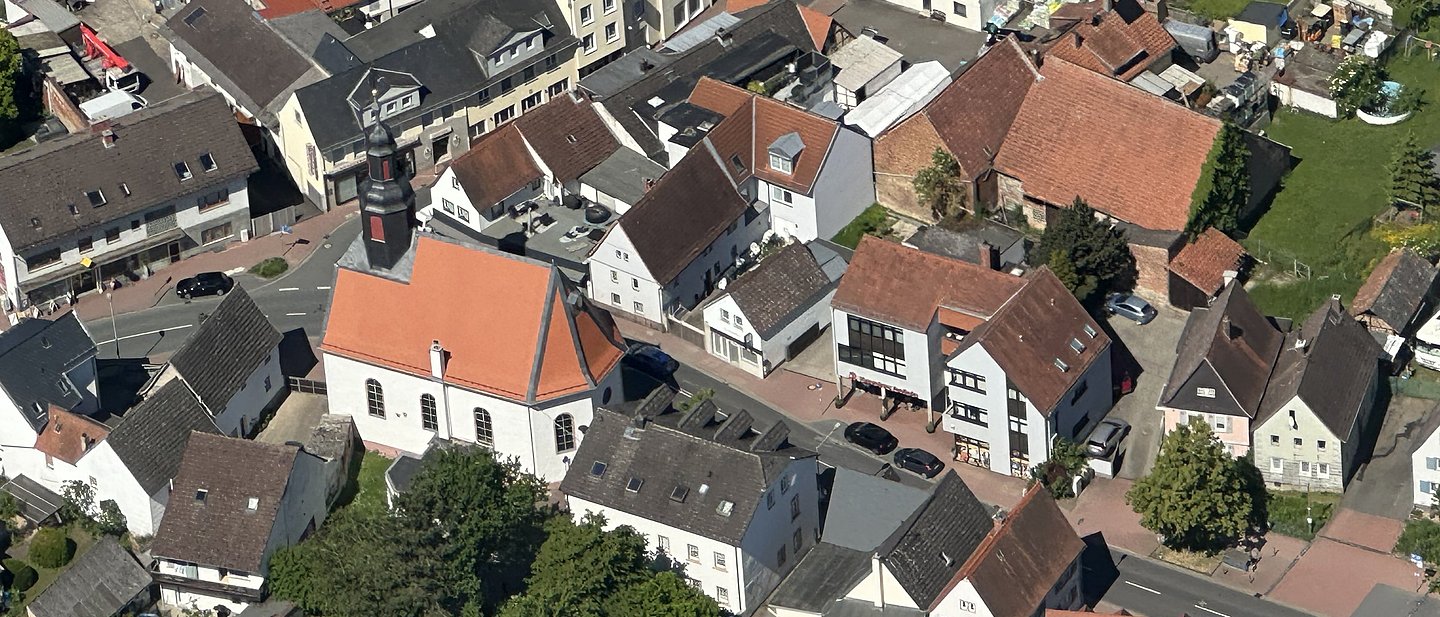 Luftaufnahme von Köppern mit der evangelischen Kirche rechts in der Bildmitte.