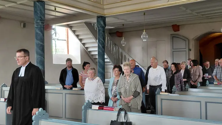 Das Foto zeigt die Jubilarinnen und Jubilare gemeinsam mit Pfarrer Frank Couard beim Einzug in die Sandbacher Kirche.