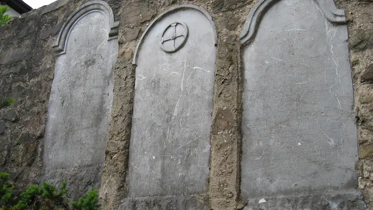 In der Mauer sind alte Grabsteine zu sehen
