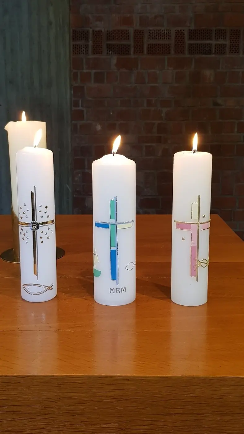 Vier verschiedene Taufkerzen.