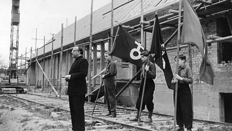 Gruppe von 4 Personen vor dem noch unfertigen Gemeidenhaus Herrnsheim
