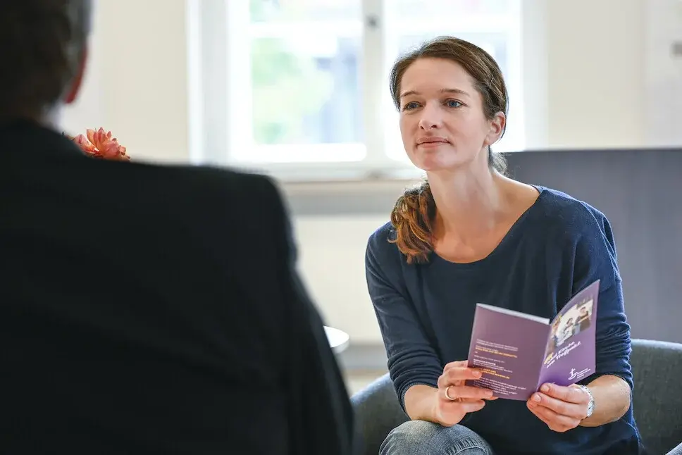 Eine Frau und ein Mann sitzen zusammen am Tisch und unterhalten sich.