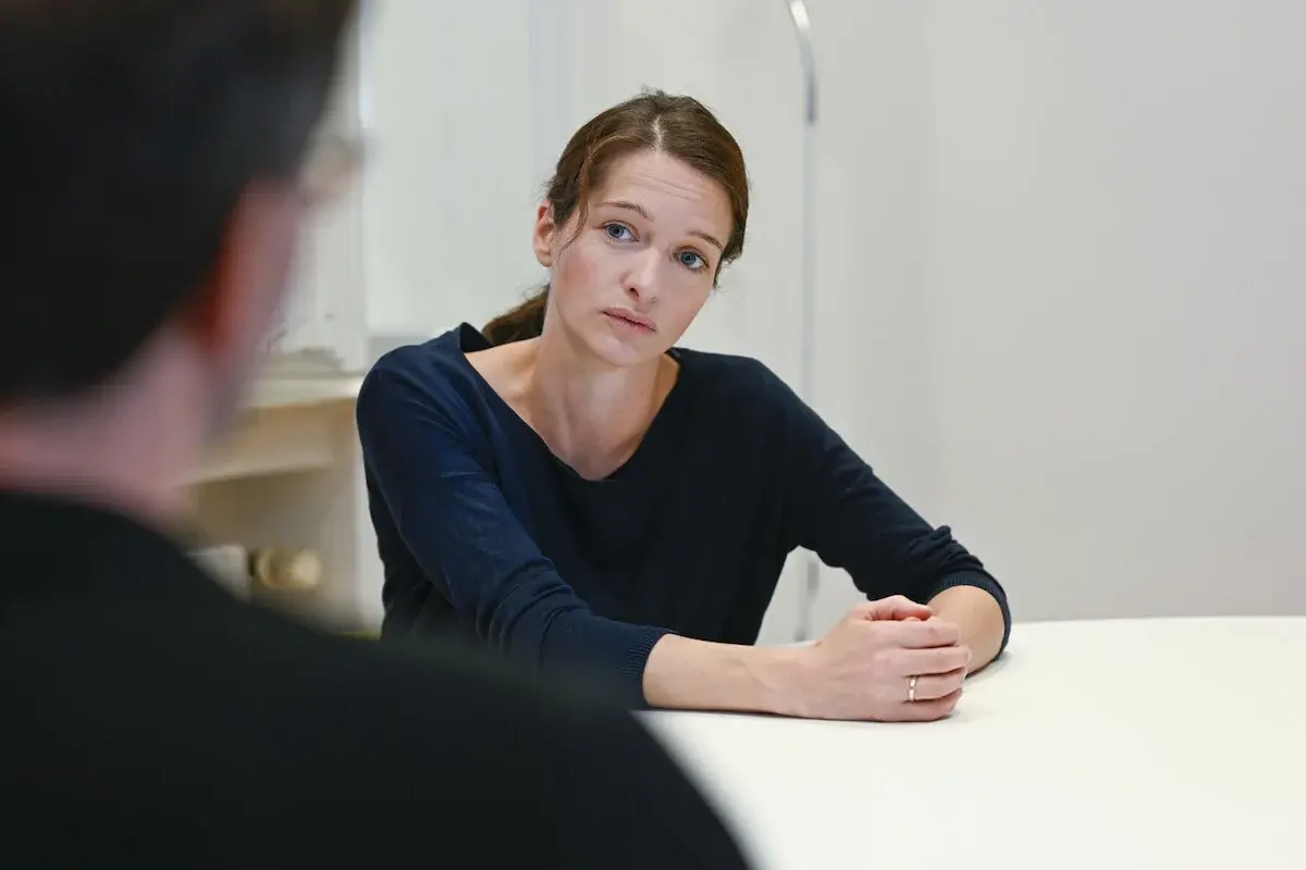 Eine Frau und ein Mann sitzen zusammen am Tisch und unterhalten sich.