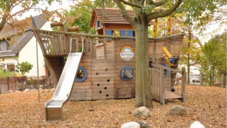 ein Holzschiff, das die Arche symbolisiert steht im Aussengelände der Kita Leiselheim