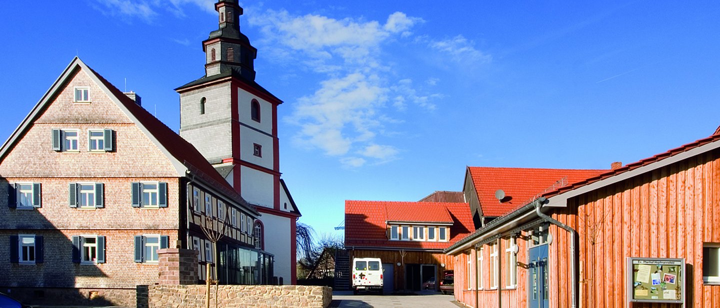 Pfarrhof Hopfmannsfeld - Gebäude und Scheune, Kirche im Hintergrund