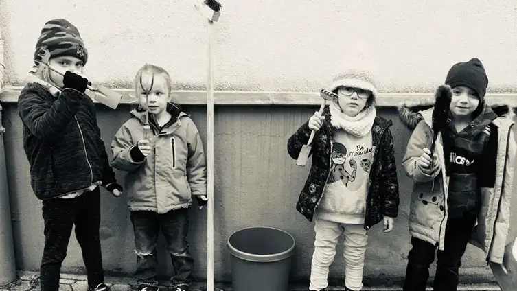 Das schwarz-weiß Foto zeigt 4 fleißige "Hausmeister-Kids" bei der Arbeit.