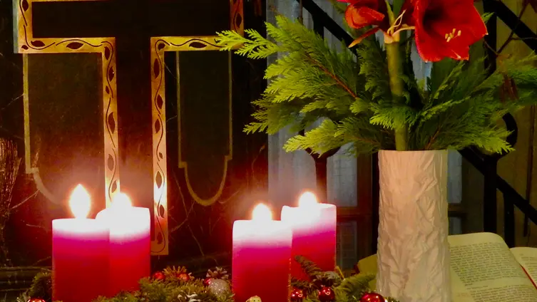 Adventskranz mit 4 brennenden Kerzen auf dem Altar