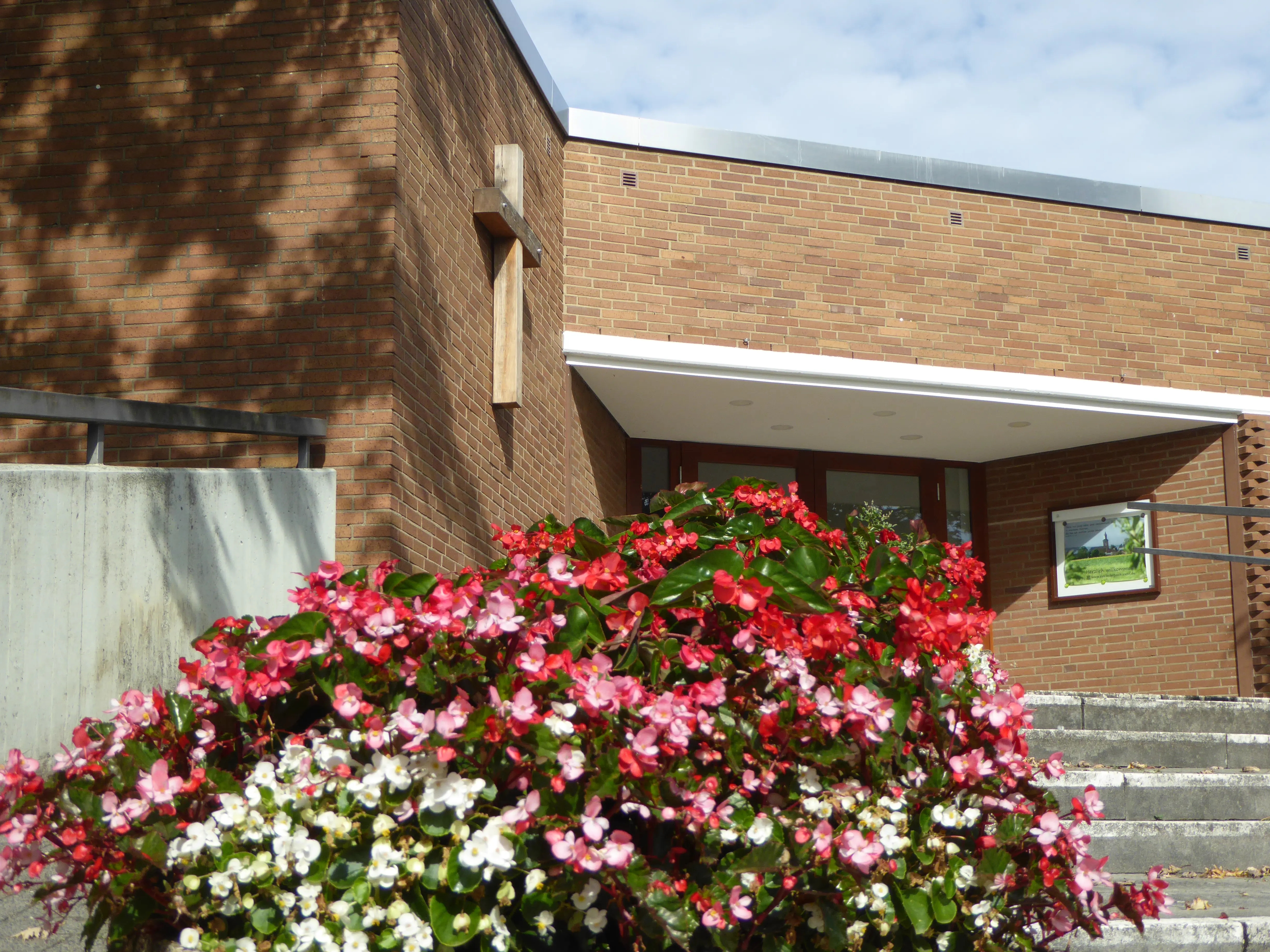 Eingang mit rot-weißen Blumen davor
