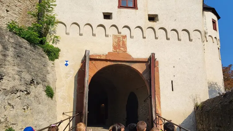 Das Foto zeigt die Kinder der Eisbärengruppe vor dem Tor der Marksburg.